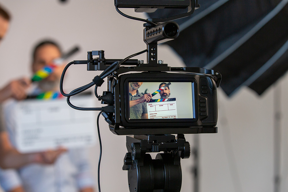 Video Camera and Video Production Studio Set. Actor, Slate Can Be Seen Through Monitor With Blurry Background